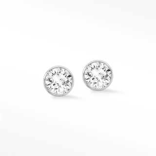A pair of elegant lab grown diamond studs bezel set in polished 14k white gold for timeless sophistication