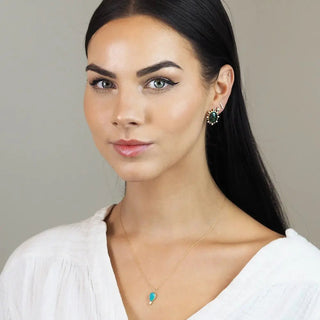A delicate lilly doublet opal 14k yellow gold necklace with a small teardrop-shaped turquoise pendant