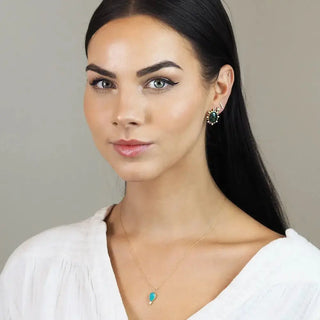 A delicate lilly doublet opal 14k yellow gold necklace with a small teardrop-shaped turquoise pendant