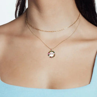 A delicate maya moonstone gold 14k necklace with a circular pendant featuring multicolored gemstones and a central stone