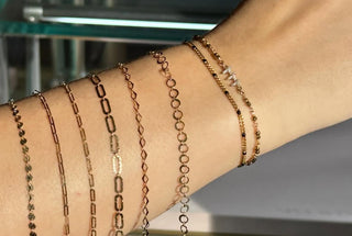 Lifestyle close-up of layered chain bracelets on a wrist