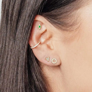 A delicate gold-toned nap earrings featuring emerald 14k yellow metal with a green gemstone evil eye design