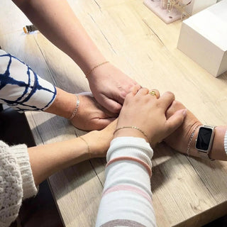 Group of hands wearing permanent bracelets
