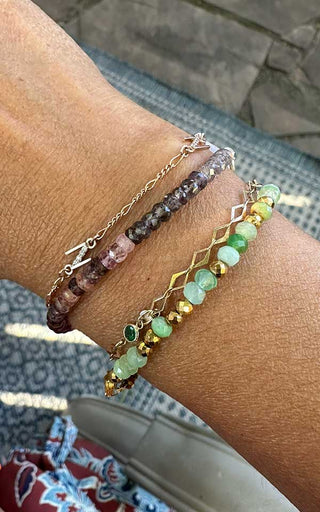 Permanent bracelet with colorful charms customized during a welded jewelry session in Denver.