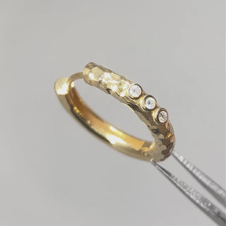 Hammered gold hoop earrings with diamonds shown while moving