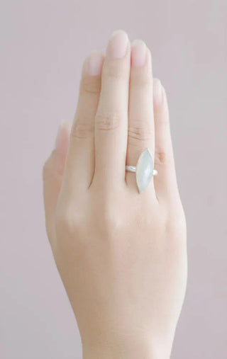 A delicate silver moonstone silver ring with a smooth light blue marquise-cut gemstone queen’s claw moonstone design