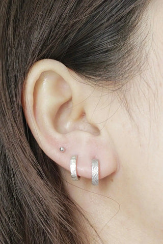 Florentine silver hoop earrings with a textured silver hammered finish reversible design by Wynning