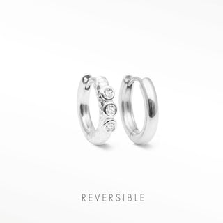 Telletubies silver hoop earrings featuring a sleek metallic band with three clear round stones on one hoop