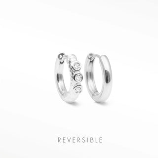 Telletubies silver hoop earrings featuring a sleek metallic band with three clear round stones on one hoop