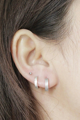 Florentine silver hoop earrings with a textured silver hammered finish reversible design by Wynning