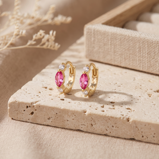 Diana pink sapphire and diamond gold huggies displayed with their gemstone faces forward