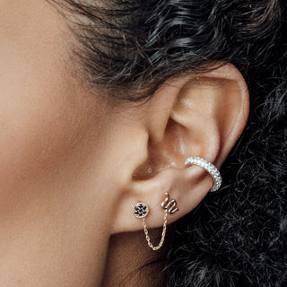 Delicate silver-toned ear cuff with clear stones paired with gold-tone flat back 14K yellow snake earrings and black gemstone pendant