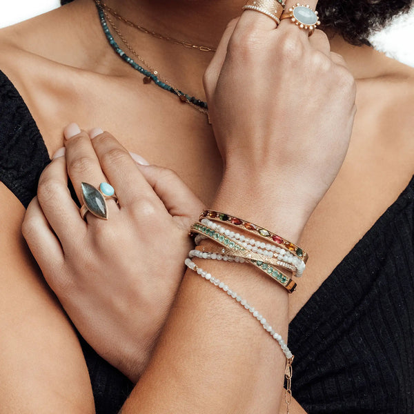 Layered gemstone bracelets, rings and necklaces styled together