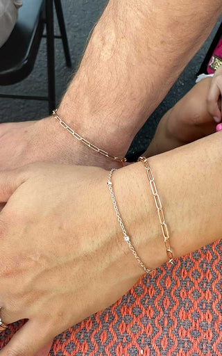 Layered permanent gold bracelets stacked closely on a client’s wrist in Denver.