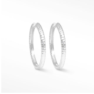 Silver hammered hoop earrings with a textured tactile surface made of sterling silver hammered metal