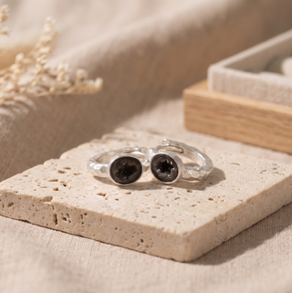 Element Mini silver hoops lying flat with round dark geode faces visible