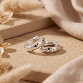 Hammered sterling silver hoops lying flat to show the textured bands