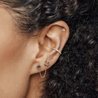 Rose gold snake-shaped ear cuff with delicate chain and black gemstone accent for trinity studs diamond collection
