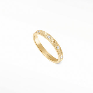 A 14k gold cigar band ring with a textured surface and three round band ring diamonds set along its side